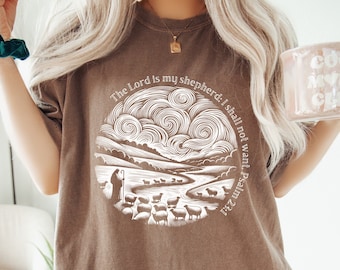 May include: A brown t-shirt with a white graphic design of a shepherd leading sheep in a field. The graphic includes the text "The Lord is my shepherd: I shall not want. Psalm 23:1."