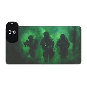 Może przedstawiać: Prostokątna podkładka pod mysz z zielono-czarną ilustracją trzech żołnierzy w ekwipunku bojowym, na zielonym, zadymionym tle. Czarna bezprzewodowa podkładka ładująca jest przymocowana do lewej strony, z symbolem ładowania bezprzewodowego.