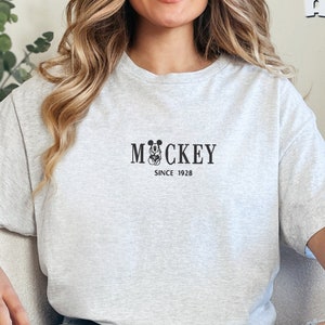 May include: A gray t-shirt with a black Mickey Mouse graphic and the text "Mickey Since 1928".