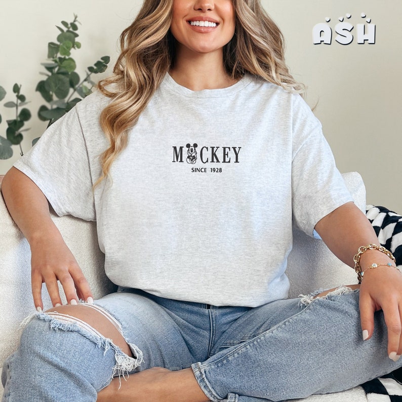 May include: A gray t-shirt with a black Mickey Mouse graphic and the text "Mickey Since 1928".