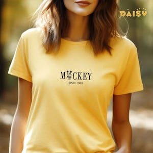 May include: Yellow t-shirt with a black Mickey Mouse graphic and the text "Mickey Since 1928".