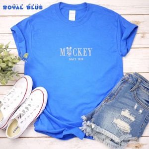 May include: A royal blue t-shirt with a white graphic of Mickey Mouse and the text "Mickey Since 1928".