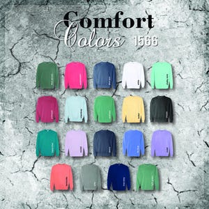 May include: A display of Comfort Colors sweatshirts in various hues, including blue spruce, watermelon, and white. The image showcases a range of colors, with each sweatshirt labeled with its corresponding color name. The text "Comfort Colors 1566" is at the top.