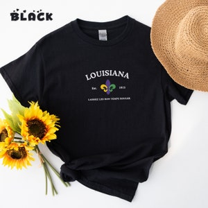 May include: Black t-shirt with a white graphic design featuring the text "LOUISIANA" with a fleur-de-lis symbol and the text "Est. 1812" and "LAISSEZ LES BON TEMPS ROULER".