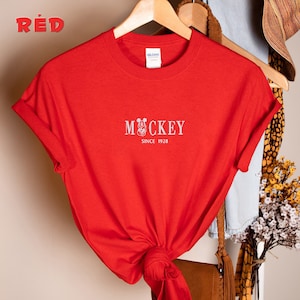 May include: Red t-shirt with a white Mickey Mouse graphic and the text "Mickey Since 1928".