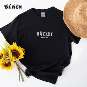 May include: Black t-shirt with a white Mickey Mouse graphic and the text "Mickey Since 1928".
