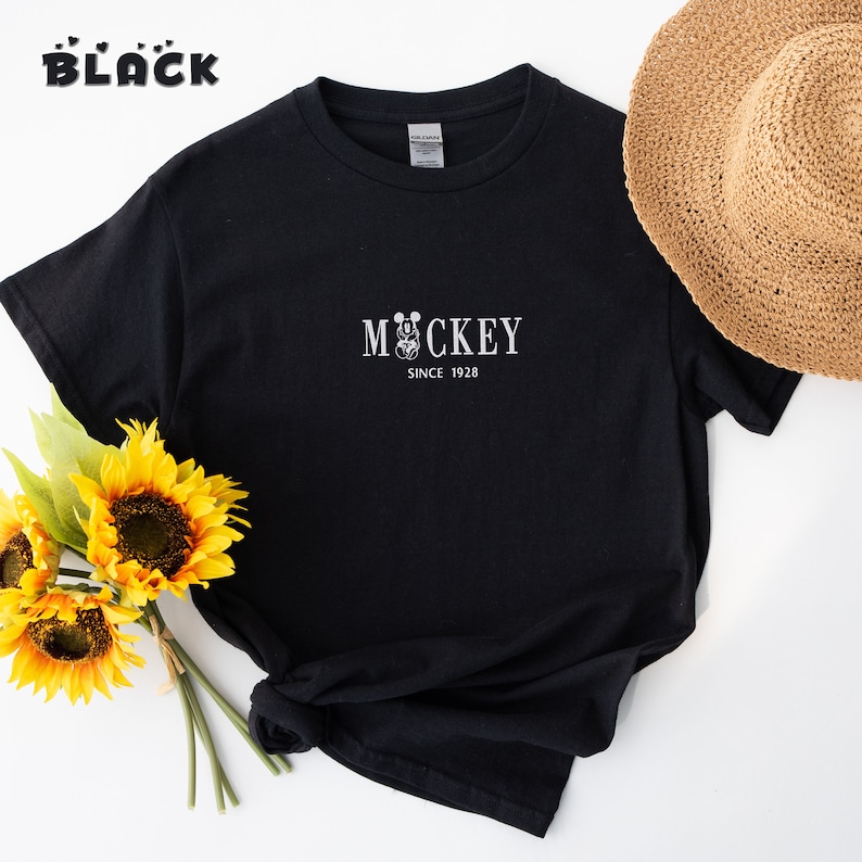 May include: Black t-shirt with a white Mickey Mouse graphic and the text "Mickey Since 1928".
