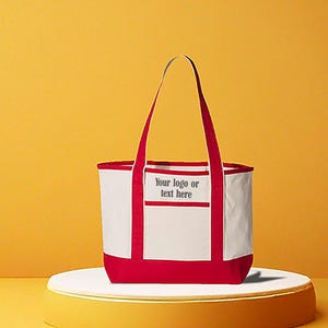 May include: A white and red tote bag with red handles and trim. The bag has a rectangular pocket with the text "Your logo or text here". The bag is on a white platform with a yellow background.