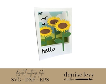 Può includere: Immagine artigianale di girasoli in un campo, con la parola "hello" in basso. I girasoli hanno petali gialli e centri marroni. Tre uccelli neri volano nel cielo. L'immagine è in una cornice bianca.