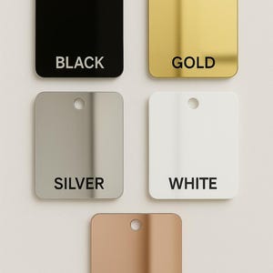 May include: Five square, rounded-corner tags in black, gold, silver, white, and rose gold. Each tag has a small hole at the top and a color name printed in black text. The tags are arranged in a square formation.