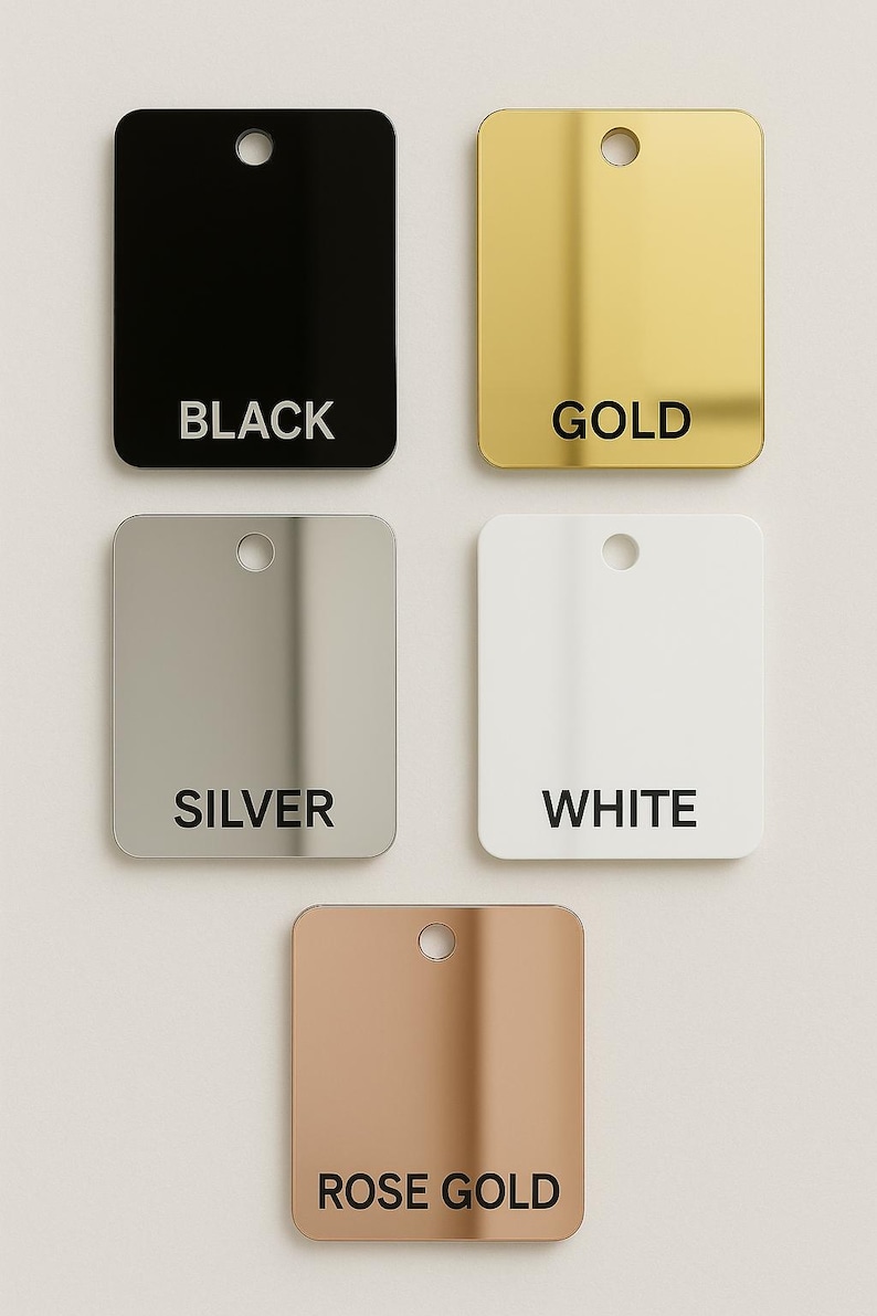 May include: Five square, rounded-corner tags in black, gold, silver, white, and rose gold. Each tag has a small hole at the top and a color name printed in black text. The tags are arranged in a square formation.