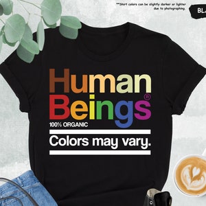May include: Black t-shirt with the text "Human Beings" in rainbow colors. The text "100% Organic" and "Colors may vary." are also printed on the shirt.