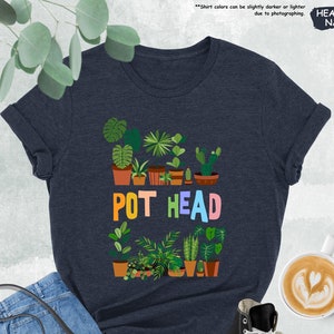 May include: A dark blue t-shirt with a graphic of potted plants and the text "POT HEAD" in rainbow colors.
