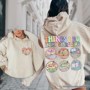 a woman wearing a white sweatshirt with patches on it