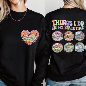 two women wearing black sweatshirts with colorful designs on them