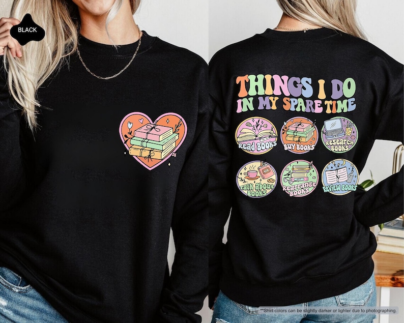 two women wearing black sweatshirts with colorful designs on them