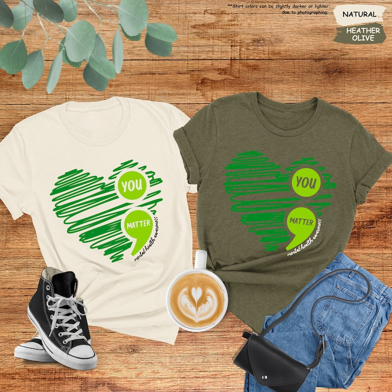 a couple of t - shirts sitting on top of a wooden floor