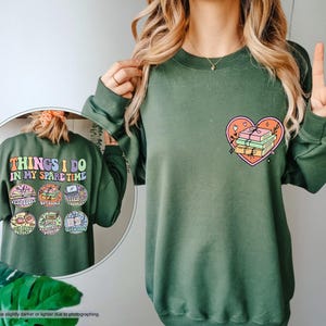 a woman wearing a green sweatshirt with a heart on it