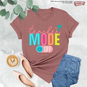 May include: A heather mauve t-shirt with the text "teacher MODE OFF" in colorful letters with a light blue power button graphic.
