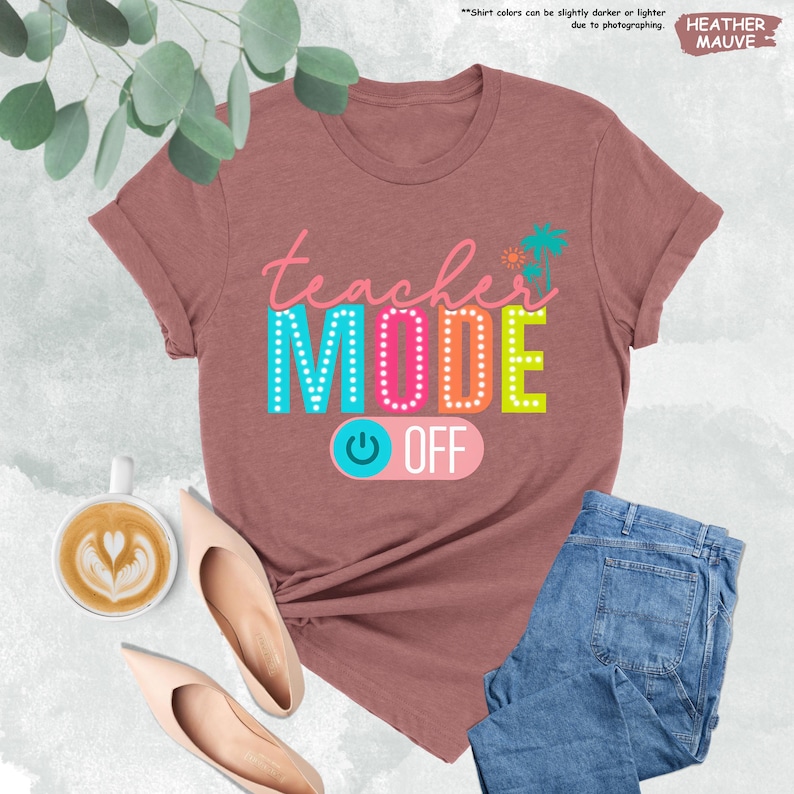 May include: A heather mauve t-shirt with the text "teacher MODE OFF" in colorful letters with a light blue power button graphic.