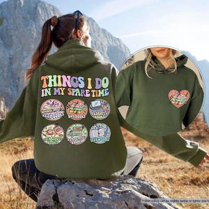 a woman sitting on a rock wearing a green hoodie