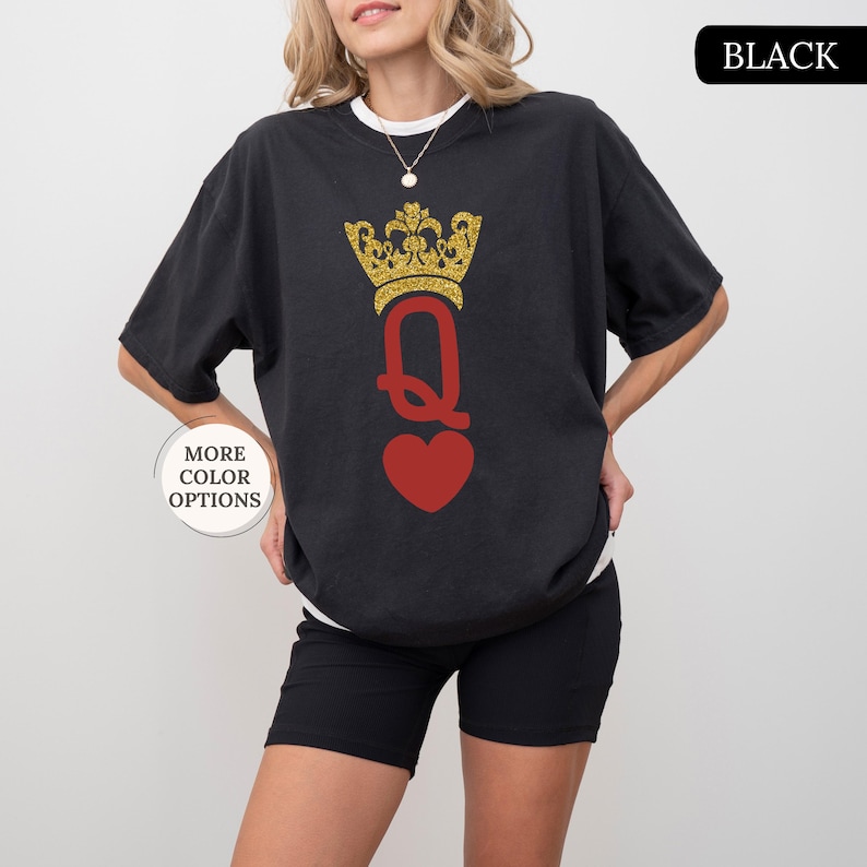 May include: Black t-shirt with a gold glitter crown and a red heart with a queen of hearts graphic. The text "BLACK" is in the upper right corner of the image.