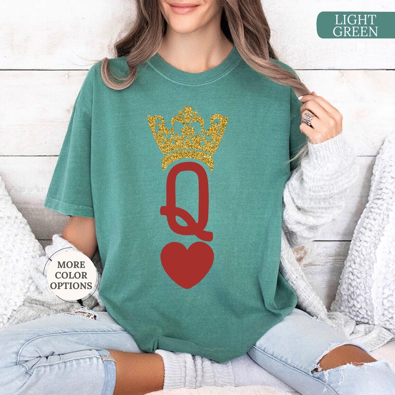May include: A light green t-shirt with a red heart and a gold glitter crown with the letter Q in the center. The text "LIGHT GREEN" is in the upper right corner of the image.