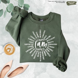 a green sweatshirt with the words on it next to a pair of shoes and a