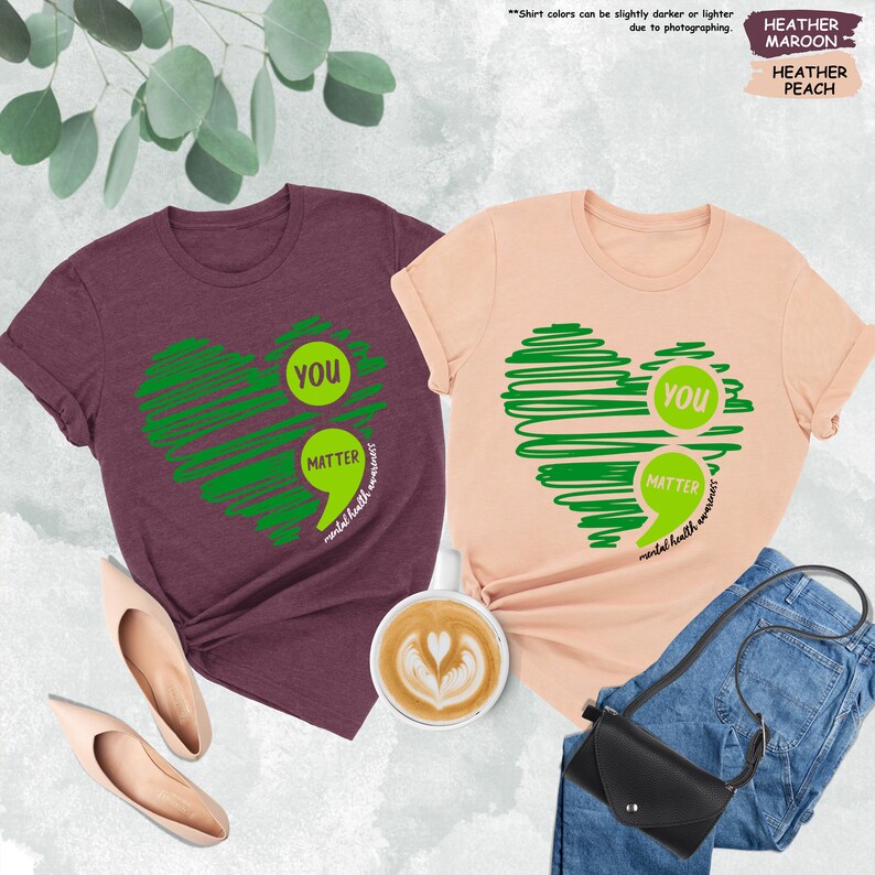 a couple of t - shirts sitting next to a cup of coffee