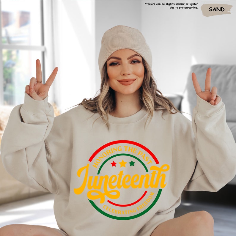 a woman sitting on the floor wearing a sweater and hat