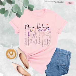 a pink t - shirt with a floral design and a cup of coffee