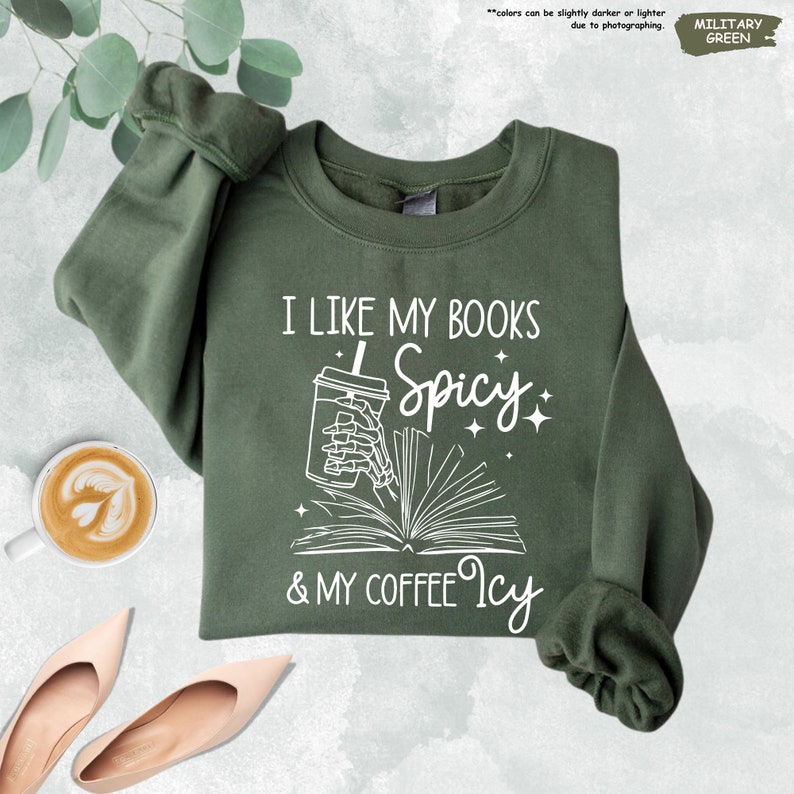 a green sweatshirt with a book and coffee next to it