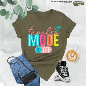 May include: A heather olive t-shirt with the text "teacher MODE OFF" in colorful letters. The text is stylized to look like a light-up sign. A power button graphic is below the text.