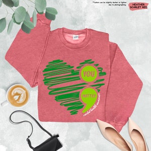 a pink shirt with a green heart on it