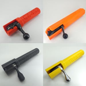 Puede incluir: Cuatro conjuntos de cerrojos de rifle en rojo, naranja, negro y amarillo. Cada cerrojo tiene un mango negro o plateado y está etiquetado con un nombre de modelo: CZ 452, Blaser R93, Sako S20 y Tikka T3x. Los cerrojos están sobre un fondo blanco.