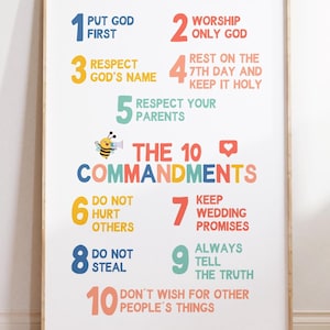 May include: A framed print featuring the Ten Commandments, with each commandment numbered and written in colorful text. The print includes a bee graphic and a heart icon, suitable for home or classroom decor.
