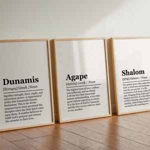 Könnte beinhalten: Drei Holzrahmen mit weißen Hintergründen und schwarzem Text. Die Drucke definieren die Wörter "Dunamis", "Agape" und "Shalom" mit ihren Ursprüngen und Bedeutungen.