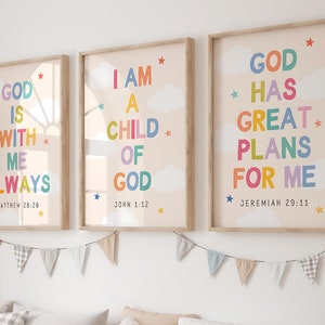 Può includere: Tre stampe da parete incorniciate con sfondo beige chiaro, nuvole bianche e stelle colorate. Il testo recita: GOD IS WITH ME ALWAYS MATTHEW 28:20, I AM A CHILD OF GOD JOHN 1:12 e GOD HAS GREAT PLANS FOR ME JEREMIAH 29:11.
