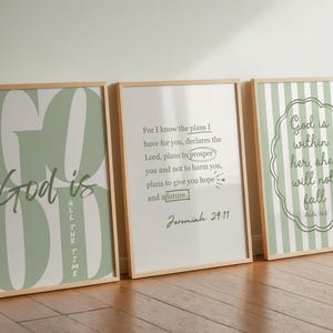 Puede incluir: Tres impresiones artísticas enmarcadas con citas inspiradoras. La primera impresión dice "Dios es todo el tiempo" en verde y blanco. La segunda impresión tiene una cita de Jeremías 29:11. La tercera impresión dice "Dios está dentro de ella, ella no caerá".