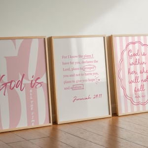 Puede incluir: Tres impresiones artísticas enmarcadas con citas inspiradoras. La primera impresión dice "Dios es todo el tiempo" en rosa sobre un fondo a rayas rosas y blancas. La segunda impresión tiene un versículo bíblico. La tercera impresión dice "Dios está dentro de ella, no caerá".