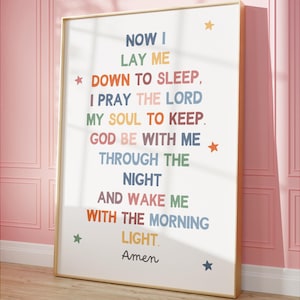 Puede incluir: Impresión enmarcada con el texto colorido de la oración «Now I Lay Me Down to Sleep». El marco de madera clara está adornado con estrellas. Ideal para un dormitorio infantil.