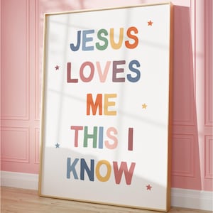 May include: A framed wall art print featuring the text JESUS LOVES ME THIS I KNOW in multi-colored block letters. The design includes small star icons scattered around the words, set against a white background within a thin light wood frame.