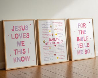 May include: Three framed prints with inspirational messages in pink and purple text. The prints have a light wood frame and are displayed on a wooden floor. The messages include "Jesus Loves Me This I Know" and "For The Bible Tells Me So."