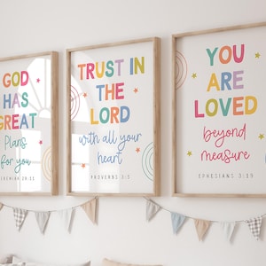 Puede incluir: Tres impresiones enmarcadas con diseños de arcoíris coloridos y citas inspiradoras. La primera impresión dice "Dios tiene grandes planes para ti" con la referencia bíblica "Jeremías 29:11". La segunda impresión dice "Confía en el Señor con todo tu corazón" con la referencia bíblica "Proverbios 3:5". La tercera impresión dice "Eres amado más allá de toda medida" con la referencia bíblica "Efesios 3:19".