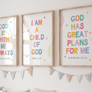 Könnte beinhalten: Drei gerahmte Wandbilder mit hellem Holzrahmen, die farbigen Text sowie kleine Stern- und Kreismotive zeigen. Die Drucke enthalten die Sätze: GOD IS WITH ME ALWAYS, I AM A CHILD OF GOD und GOD HAS GREAT PLANS FOR ME.