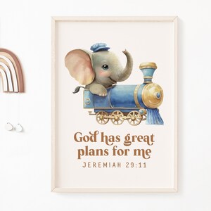 Puede incluir: Una ilustración de acuarela de un elefante gris con un sombrero azul montando un tren azul y dorado. El texto "Dios tiene grandes planes para mí" está escrito en marrón debajo de la imagen, con la referencia bíblica "Jeremías 29:11" debajo.