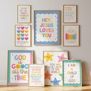 Puede incluir: Una colección de impresiones artísticas enmarcadas con citas inspiradoras e ilustraciones coloridas. Las impresiones presentan frases como "Hey Jesus Loves You", "God is Good All the Time" y "I Am a Child of God". La obra de arte incluye corazones, estrellas y un arcoíris.