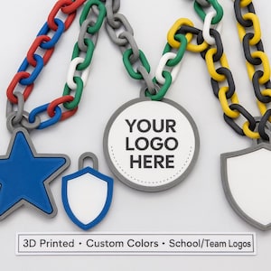 May include: A collection of 3D-printed medals with colorful chain necklaces. The medals include a blue star, a shield, and a round medal with the text "YOUR LOGO HERE". The text "3D Printed • Custom Colors • School/Team Logos" is also visible.