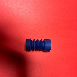 Könnte beinhalten: Ein blauer, gummibandartiger, wellenförmiger Rohrverbinder.