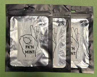 May include: Three sealed, clear plastic packages with a black border. Each package features a white graphic of a hand gesture and the words "FK'N MINT" in black. A circular sticker with the number "23" is also visible on each package.